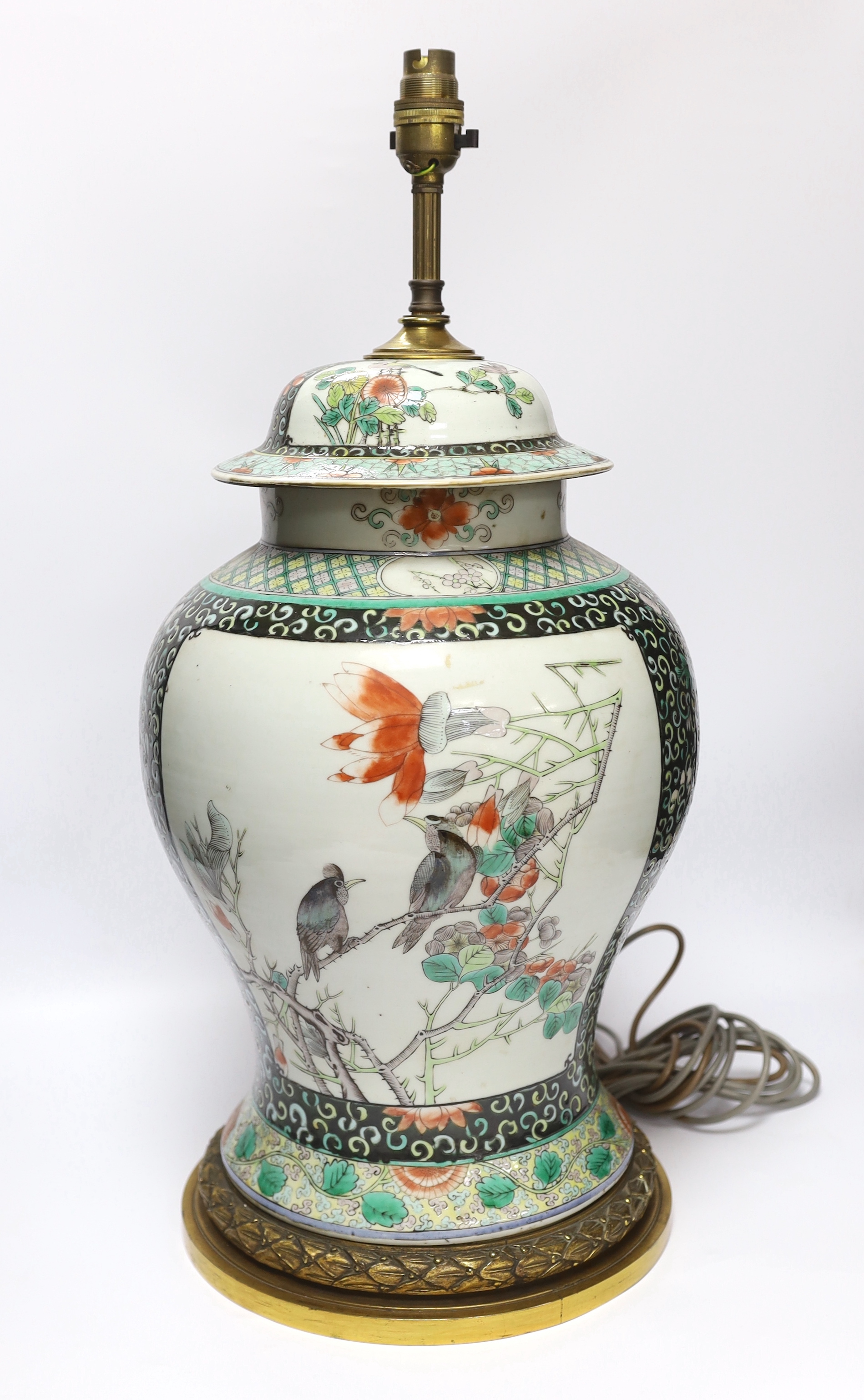 A Chinese famille verte porcelain baluster vase and cover, 19th century, decorated with birds amongst branches and blossom on decorative gilt metal base (now converted to a table lamp and drilled), 56cm total